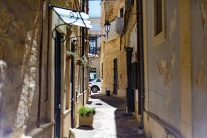 an alley with a car driving down a street at Apartment Don Giuliano Centro in Lecce