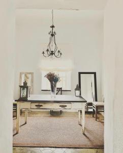 Una habitación con una mesa con un jarrón de flores. en El Quinto de Luciañez en Ventas con Peña Aguilera