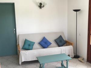 a living room with a couch with blue pillows at Case à Lili, joli haut de villa face à la mer dans le bourg. in Terre-de-Haut