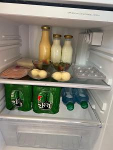 伊瓦格的住宿－Glamping Akaya，装满瓶子和牛奶罐子的冰箱