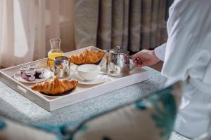 a man standing at a table with a tray of pastries at Roslin Beach Hotel in Southend-on-Sea