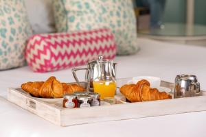 a tray of croissants and orange juice on a table at Roslin Beach Hotel in Southend-on-Sea