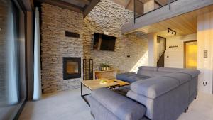 a living room with couches and a brick wall at BLACK ROCKS domki na wynajem in Nowy Sącz