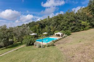 an estate with a swimming pool in a field at Fattoria La Striscia appartamenti in Gambassi Terme