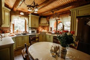 a kitchen with a table with flowers on it at Садиба "Маланка" in Mykulychyn