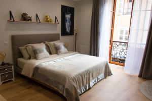 1 dormitorio con cama y ventana grande en Charming studio in the heart of the pedestrian area, en Annecy