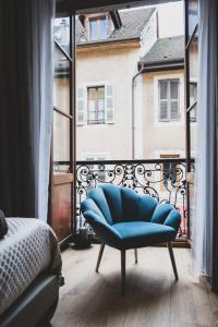 una silla azul sentada frente a una ventana en Charming studio in the heart of the pedestrian area, en Annecy