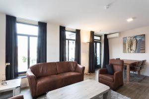 - un salon avec deux chaises et une table dans l'établissement Hello Zeeland - Appartement Wijngaerde Residence 19, à Domburg