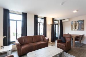 a living room with two chairs and a table at Hello Zeeland - Appartement Wijngaerde Residence 19 in Domburg