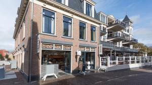 a brick building with a white bench in front of it at Hello Zeeland - Appartement Wijngaerde Residence 19 in Domburg