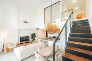 a staircase in a living room with white walls at Lumina at Flats Punta Cana Village in Punta Cana