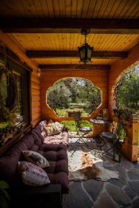 Sala de estar de una cabaña de madera con sofá en Садиба "Маланка", en Mykulychyn