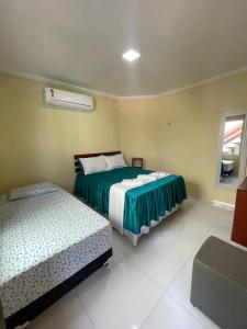 a bedroom with two beds and a window at Chalés Paraiso de Pipa in Pipa +14 photos