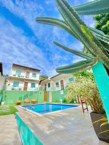 een zwembad met een palmboom en een gebouw bij Chalés Paraiso de Pipa in Pipa
