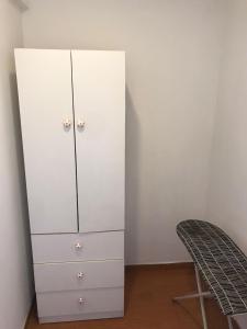 une armoire blanche dans une pièce avec une chaise dans l'établissement Hermoso Departamento en Guardia Civil - Chorrillos, à Lima