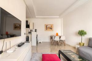 ein weißes Wohnzimmer mit einem Sofa und einem Tisch in der Unterkunft SUITE APPARTEMENT BOURGOGNE 2 pièces in Casablanca