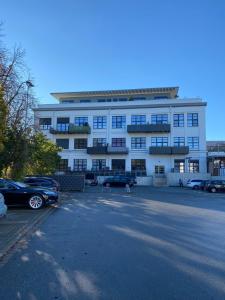 un gran edificio blanco con coches aparcados en un aparcamiento en Fabella Flats Forchheim, en Forchheim