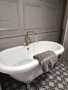 a white bath tub with a towel on a floor at Chateau-une - a Beautiful historic medieval holiday rental. in Confolens +46 photos