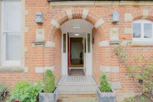 a brick house with an archway leading to a door at 100 Banbury Road Oxford - formerly Parklands in Oxford
