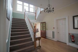 una escalera en una casa con una lámpara de araña en 100 Banbury Road Oxford - formerly Parklands en Oxford