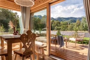 Habitación con una gran puerta de cristal con mesa y sillas. en Śnieżna Dolina - Sobiczkowa Bór Luxury Chalets en Kościelisko