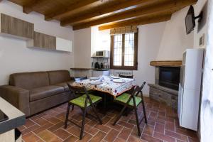 eine Küche und ein Wohnzimmer mit einem Tisch und einem Sofa in der Unterkunft Piccolo Chalet in Ponte di Legno