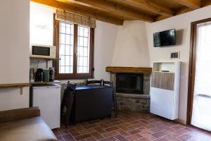 a kitchen with white appliances and a fireplace at Piccolo Chalet in Ponte di Legno