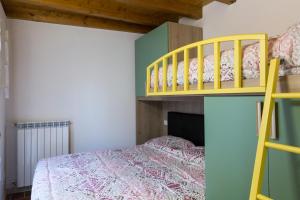 a bedroom with a bunk bed with a yellow ladder at Piccolo Chalet in Ponte di Legno