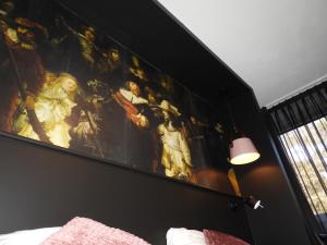 Bladel的住宿－hotel de Tipmast，卧室墙上有绘画作品