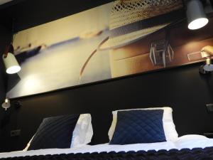 1 dormitorio con 1 cama con sombrero en la pared en hotel de Tipmast, en Bladel