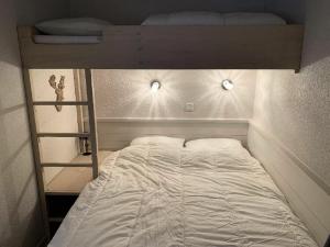 un letto con lenzuola e cuscini bianchi in una camera da letto di Residence Antares - maeva Home ad Avoriaz