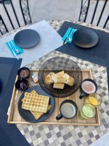 una mesa con un plato de pan y gofres. en Le Mas de Mirabel, en Mirabel-aux-Baronnies