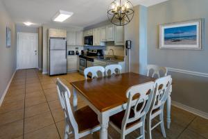 a kitchen and dining room with a wooden table and chairs at Sandpebble Beach Club Surfside Beach a Ramada by Wyndham in Myrtle Beach