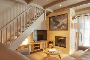 un salon avec un escalier et une télévision dans l'établissement Val de Ruda Luxe 16 by FeelFree Rentals, à Baqueira-Beret