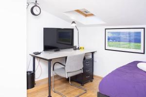 sypialnia z biurkiem, telewizorem i łóżkiem w obiekcie Lovely 2BDR Loft Apartment w Sarajewie