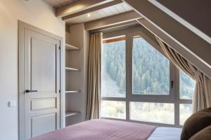 sypialnia z dużym oknem i łóżkiem w obiekcie Val de Ruda Luxe 16 by FeelFree Rentals w mieście Baqueira-Beret