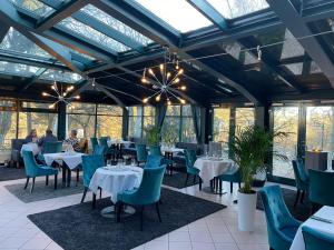 a dining room with tables and chairs and windows at Parkhotel Waldschlösschen in Annaberg-Buchholz