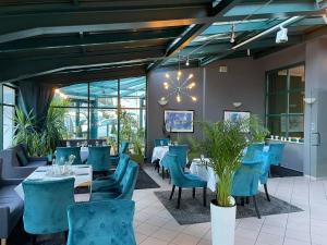 a dining room with blue chairs and tables at Parkhotel Waldschlösschen in Annaberg-Buchholz