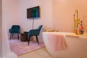 baño con 2 sillas, bañera y TV en Vila Kotlina - High Tatras 2023 en Vysoké Tatry