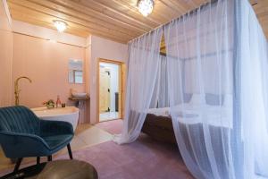 La salle de bains est pourvue d'une baignoire, d'un lit et d'une chaise. dans l'établissement Vila Kotlina - High Tatras 2023, à Vysoké Tatry