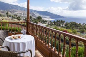 a table on a balcony with a view of the ocean at Parador de La Palma in Breña Baja