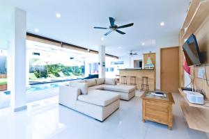 a living room with a white couch and a ceiling fan at 3BR Del Mar Beach Villas Near La Plancha Seminyak in Seminyak