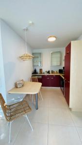 une cuisine avec une table en bois, une table et des chaises dans l'établissement PureNature Appartement, à Obersontheim