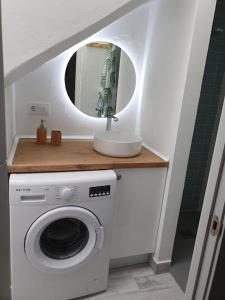 a bathroom with a washing machine and a mirror at CASA MAMA CARINA in Agüimes