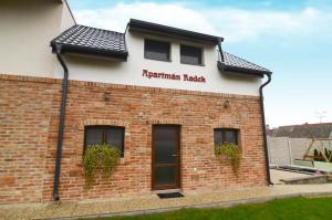 un bâtiment en briques avec un panneau indiquant la présence de briques régimentaires dans l'établissement Apartmány Zaječák, à Zaječí