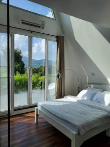 a bedroom with a bed and a large window at Phrao Camping Village in Ban Nong Hai