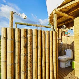 uma cerca de madeira em frente a um WC num deque em BubbleSky Glamping 40 min from Medellin em El Retiro