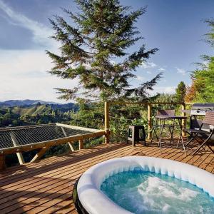 a hot tub on a wooden deck with a tree at BubbleSky Glamping 40 min from Medellin in El Retiro