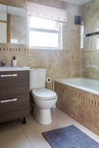 a bathroom with a toilet and a tub and a sink at Spacious 4 Bed, Parking, Close to Docks in Litherland