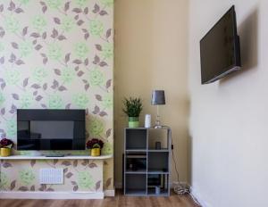 uma sala de estar com uma televisão de ecrã plano e um suporte de televisão em Spacious 4 Bed, Parking, Close to Docks em Litherland